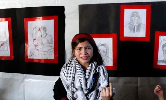 Fatima Al-Za’anin, a displaced Palestinian girl from Beit Hanoun (Gaza), speaks about her drawings in an art exhibition organized by UNRWA in Gaza City as part of its mental health and psychosocial support services.